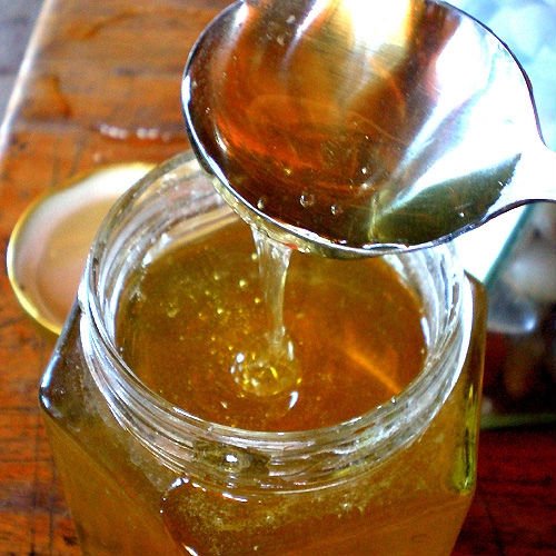 The honey comb (honey with wax) with wooden  frame  andcovered with white wax and plenty of honey.