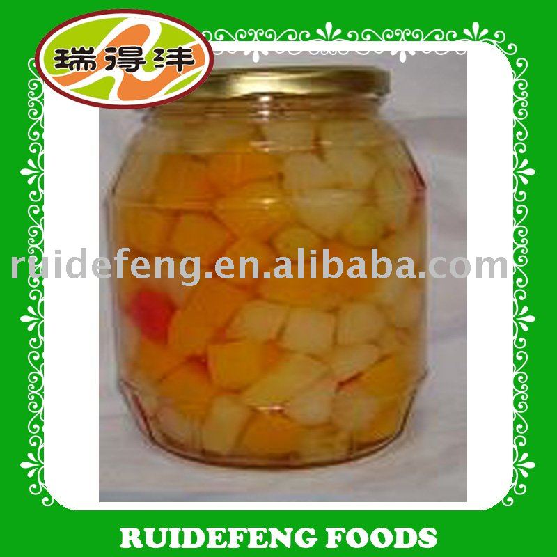 canned fruit cocktail in  glass  (tropical fruits peach, pear, pineapple,  grape , cherry)